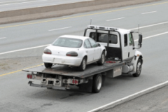 tow truck carrying vehicle on highway